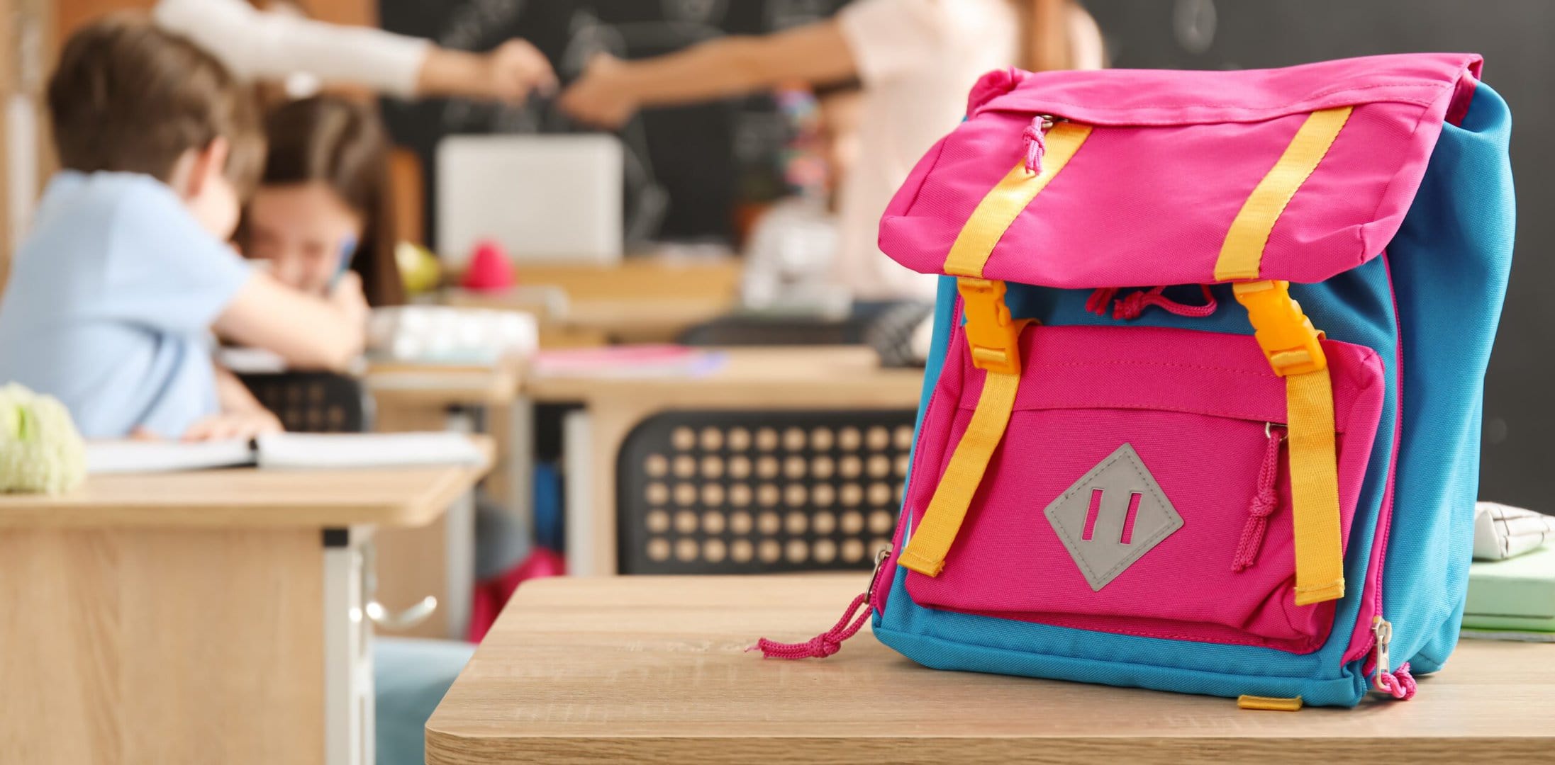 Child's,Backpack,On,Desk,In,Classroom